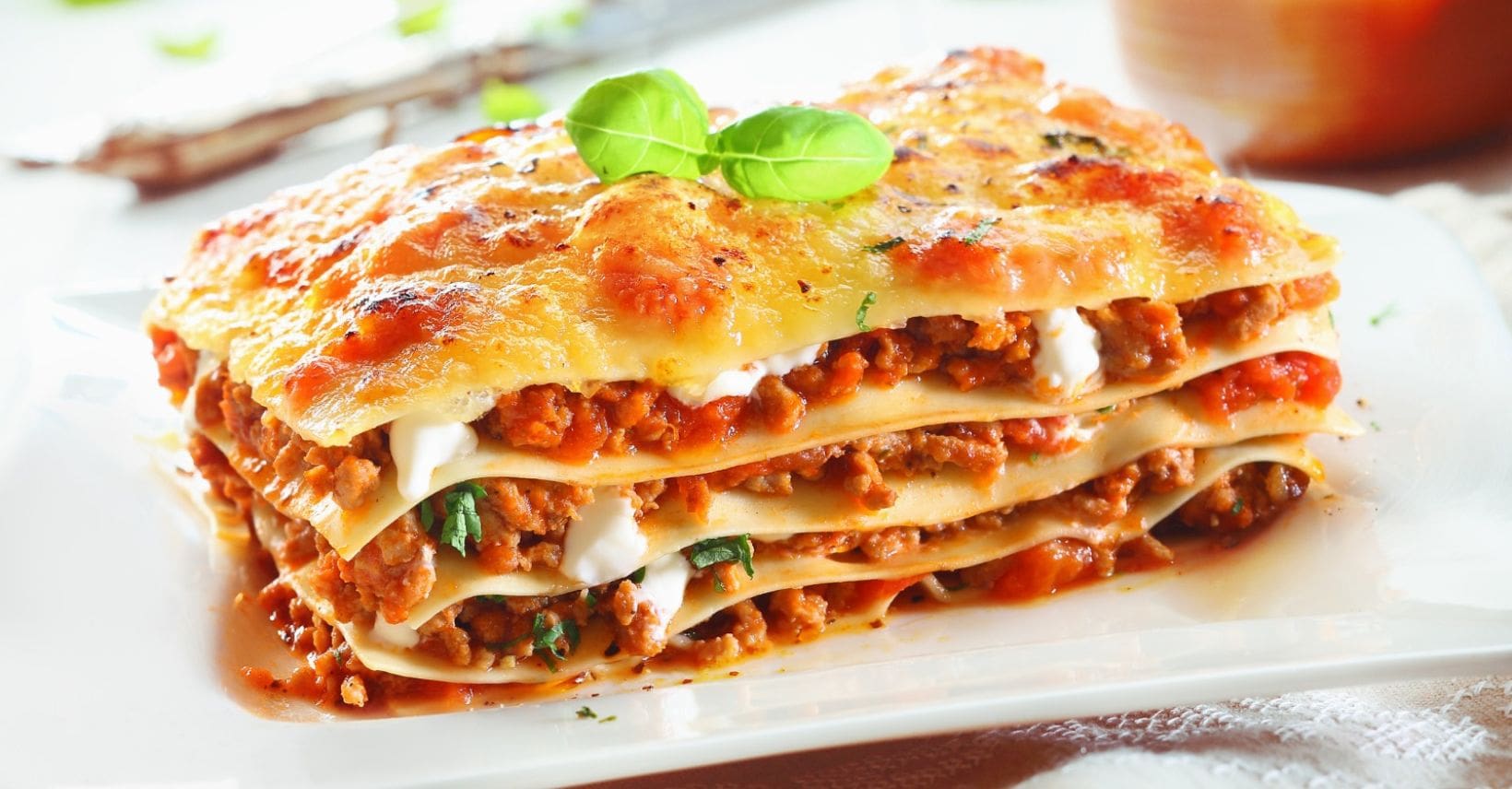 Porzione di lasagne alla bolognese su un piatto bianco